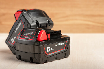 Battery for cordless drill. Screwdriver battery. Two batteries with a charge indicator lie on a...