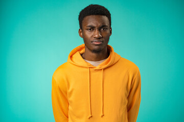 Fototapeta premium Portrait of young handsome afro-american guy sadly looking at camera in studio