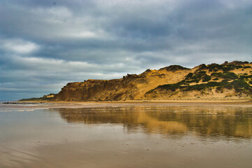 Fototapeta na wymiar Beach and tall sand dunes under a threatening sky, Wilsons Promontory, Victoria, Australia 