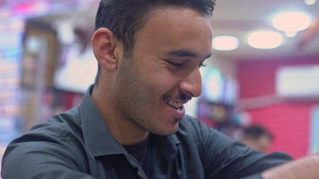 Young Arab barber cuts man's hair with scissors in a barbershop. Men's hairstyling and haircutting in the salon. 