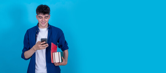isolated student with mobile phone and books on blue background