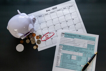 Tax Concept: April 18, 2022 IRS deadline for filing tax forms - shown with piggybank and coins