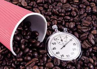 Paper cup of red color and times on a background of coffee beans