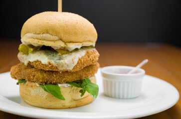 Close-up of homemade tasty chicken burger on wooden table.