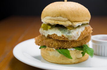 Close-up of homemade tasty chicken burger on wooden table.