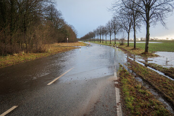 country road is flooded after heavy rainfall