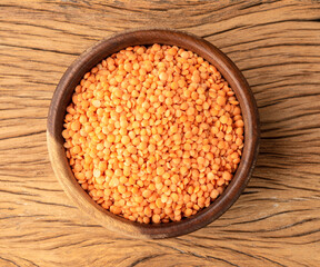 Orange lentil in a bowl over wooden table