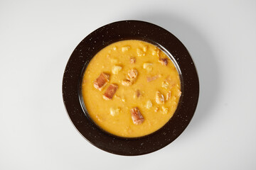 Mote pata is a traditional ecuadorian soup made from mote, pork, sausage and sambo seeds. It’s served on a white plate with a white background