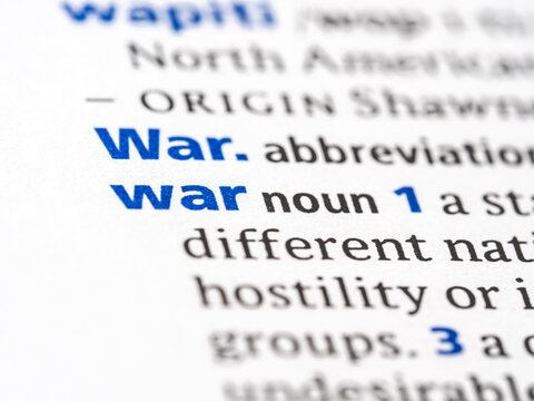 War - English dictionary definition of the word - photo of a dictionary page with paper grain texture - selective focus on the word
