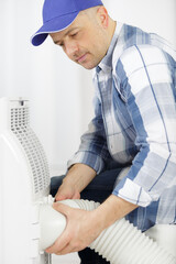 male technician repairing air conditioner