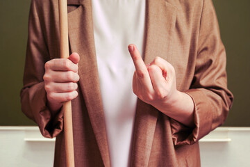 Woman teacher showing middle finger on school blackboard in the classroom