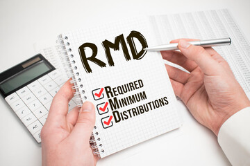 Business and finance concept. A businessman holds a sign in his hands which says RMD - REQUIRED...