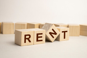 word Rent with wood building blocks, light gray background. document with numbers on background, business concept. space for text in left. front view