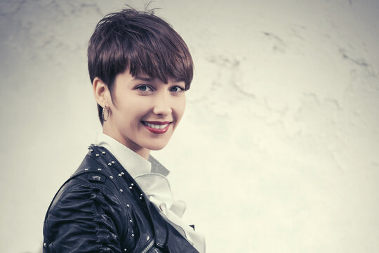 Happy young woman in leather jacket with pixie hair style
