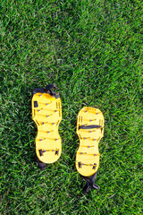 Yellow lawn aerator sandals with nails for lawn cultivation. Shoes with aeration spikes for cultivation and revitalizing green grass of your garden