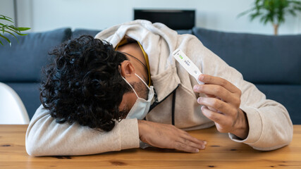 Sad caucasian man makes a home test device Covid19 virus with positive result