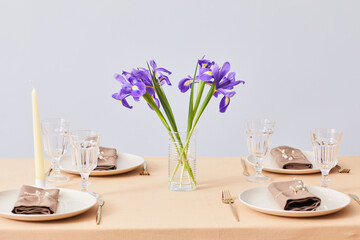 Minimal background image of Spring dinner table decorated with Iris flowers, copy space