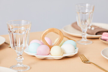 Minimal closeup of cute Easter eggs platter on elegant dinner table decorated for Spring, copy space