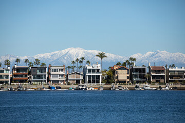 Long Beach California in winter, view over the bay at houses with boats and mountains with snow, Belmont Shore - obrazy, fototapety, plakaty