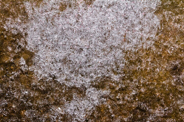 Close up photo of frozen brown colored ground surface texture background.