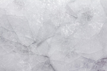Close up photo of frozen cracked ice surface texture background.