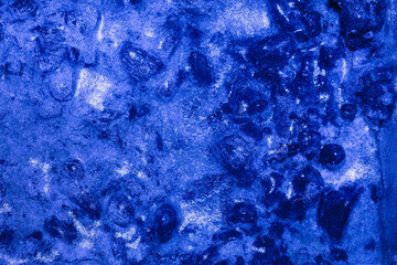 Photo of blue toned frozen wooden coal covered in ice surface texture.