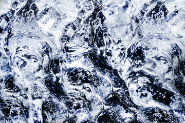Photo of blue toned frozen water splashes surface texture.