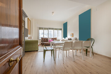 Hall of a vacation rental home with a dining room with eight chairs, a pantry with crockery on the shelves and a large window with views in the background