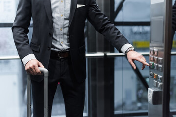 cropped view of man with baggage pressing button in modern elevator © LIGHTFIELD STUDIOS