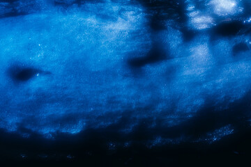 Photo of glowing and highlighted snow surface with ice pieces.