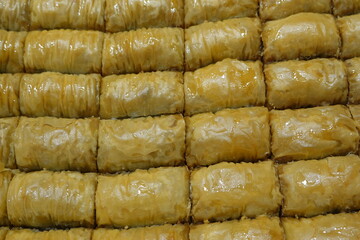 Delicious traditional Turkish Baklava dessert arranged in rows close-up macro full frame pattern