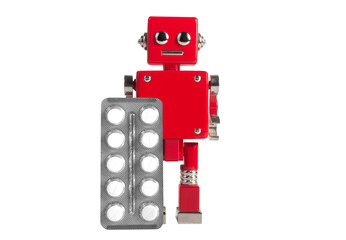 Isolated photo of red colored metal miniature robot toy standing with pills blister on white background.