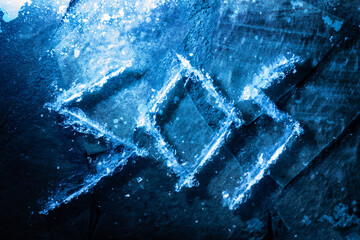 Photo of sos word, meaning save our souls, scratched on cracked ice surface on dark background. Winter time help and rescue concept.