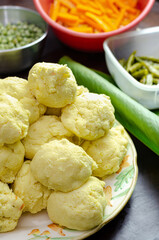 Native woman cooking typical Colombian and Mexican traditional dish made with corn dough and stuffed with chicken, pork, pork ribs, vegetables; wrapped in banana leaves, steamed.