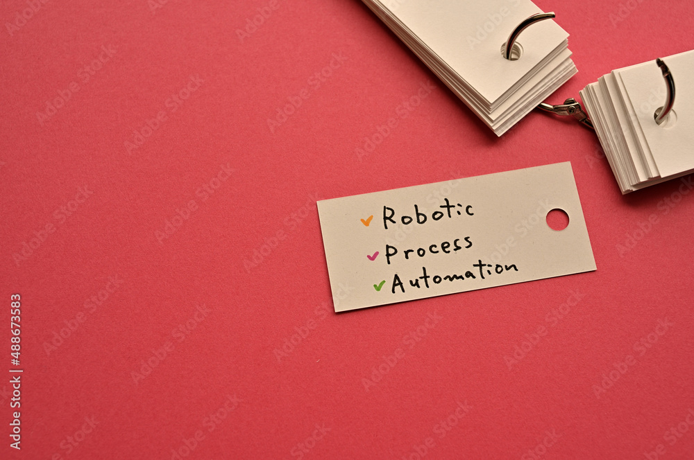 Poster there is a small card placed on a red background paper with the word robotic process automation writ