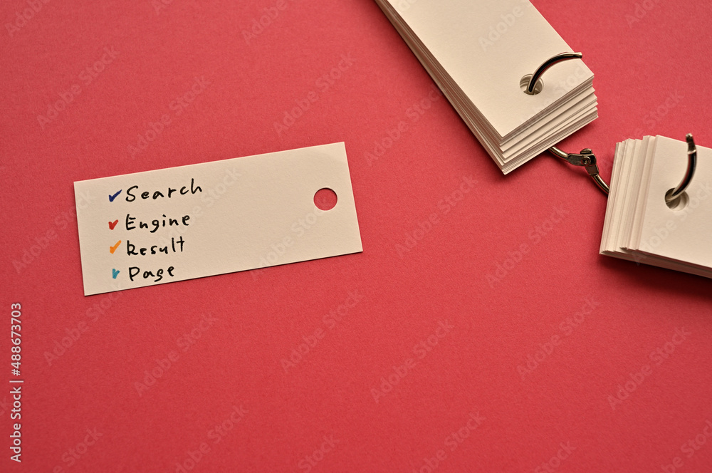 Poster there is a small card placed on a red background paper with the word search engine result page writt