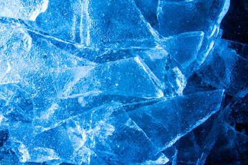 Photo of blue toned frozen cracked ice pieces surface texture.