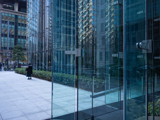 glass wall architecture and isolated person standing on the street in tokyo