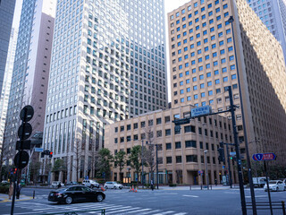 Fototapeta na wymiar cityscape of business district in tokyo; office buildings and car crossing the cross road