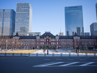 the retro exterior of tokyo station and urban office buildings behind it