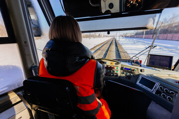 Female tram driver on workplace, view from behind