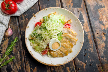 Salad caesar with chicken top view on old wooden table, top view