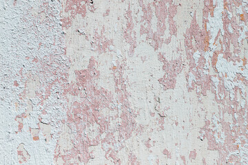 Cracked, peeling, painted concrete wall