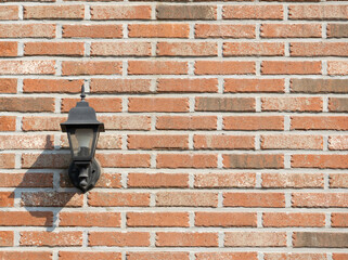 A wall lamp installed on the wall of a house with red bricks