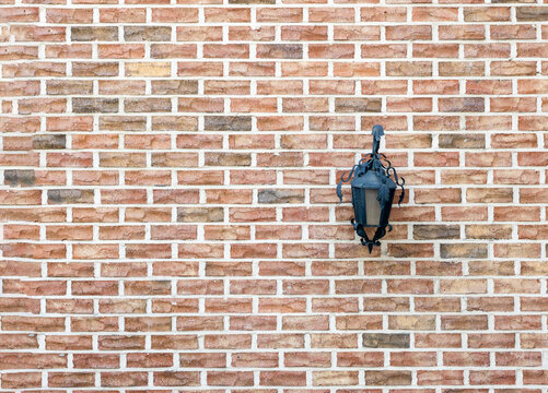 wall lamp installed on red brick house wall © Kyusang