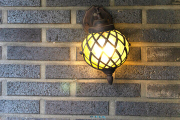 Trunnion wall lamp installed in dark gray brick