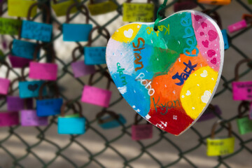 Love heart and love padlocks on a wire chain fence. Bright and colourful. Traditional symbol of...