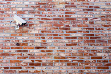 CCTV camera installed on a red brick wall