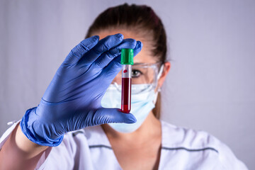 Mujer investigadora mirando y analizando muestra de sangre. Buscando la cura
