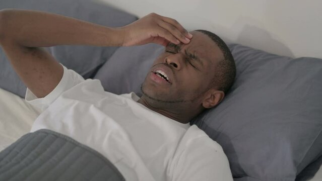 African Man having Headache while Sleeping in Bed, Close up